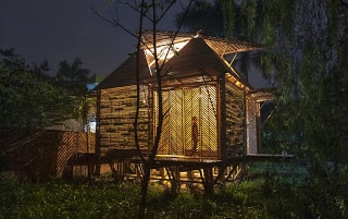 Casa de bambú iluminada en la noche