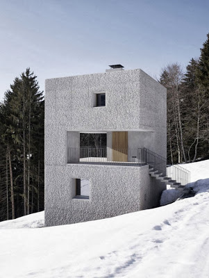 Pequeña casa en forma de cubo para climas frios en la montaña