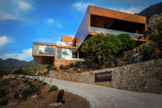 Diseño de moderna casa en la montaña construida en hormigón, imponente fachada y decoración rústica