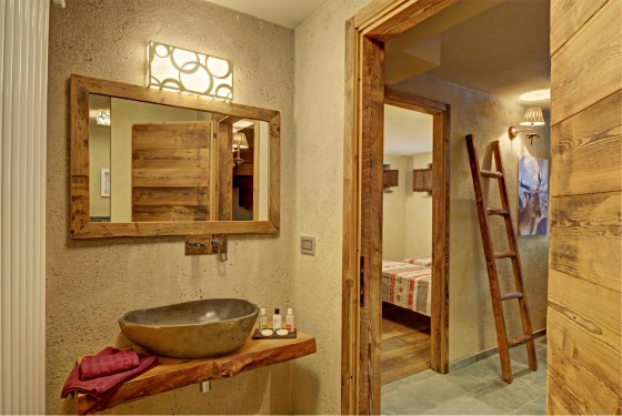 Diseño de cuarto de baño rústico con lavatorio de piedra