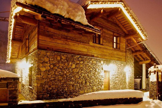 Diseño de casa de piedra y madera, foto tomada de noche