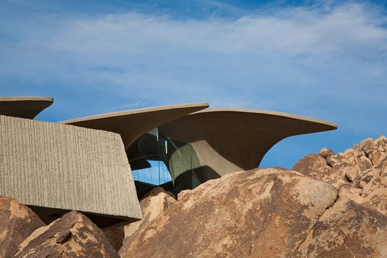 Fachada de casa orgánica mostrando las estructuras del techo