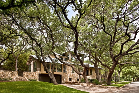 Hermosa casa rústica de piedra rodeado de grandes árboles