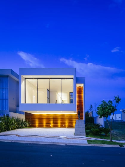 Fachada de moderna casa de dos pisos iluminada por la noche