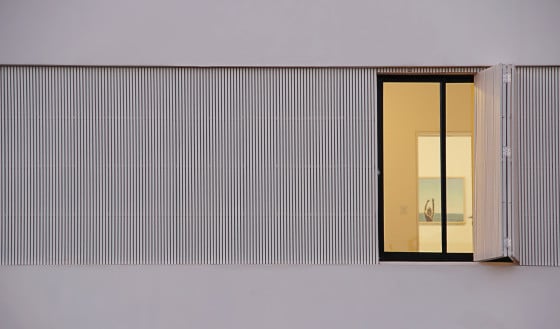 Detalle de ventanas con persianas exteriores de madera verticales