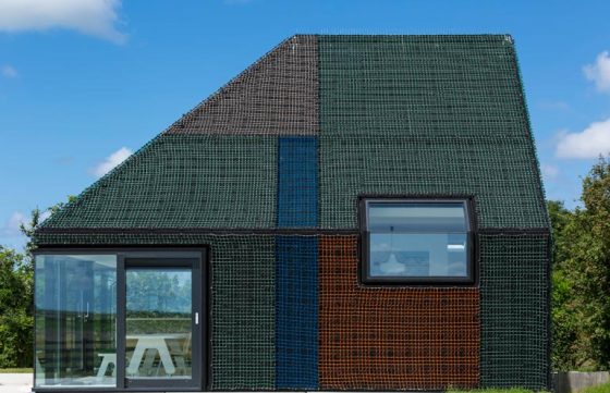 Casa pequeña de madera cubierta de redes de colores