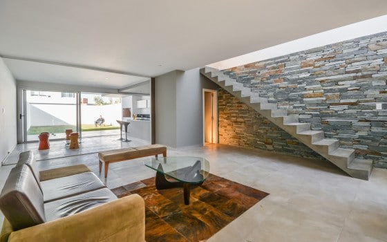 Diseño de interiores de sala sencilla con escaleras de concreto