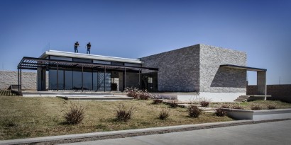 Fachada de casa moderna con piedra y grandes cristales