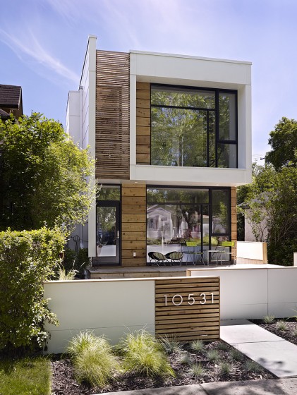 Fachada casa dos plantas con grandes ventanas 