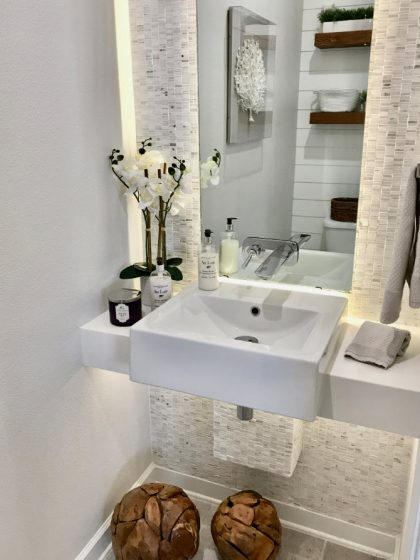 Lavatorio de baño con fondo piedra y espejo retroiluminado