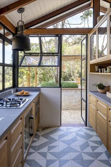 Diseño de cocina combina rústico y moderno, techo inclinado y pisos con figuras geométricas 