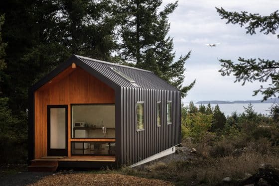 Diseño de cabaña estilo escandinavo, exterior metálico e interiores de madera