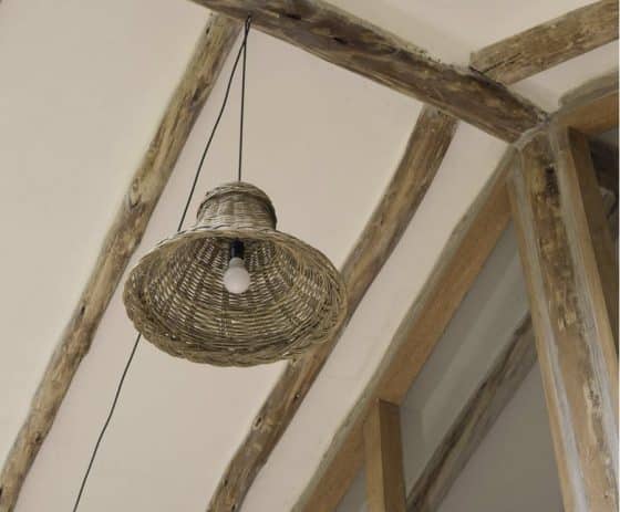 Diseño interior de techo rústico, hecho con troncos de árboles y lámpara de fibra natural mimbre 