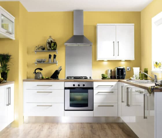 Luminosa cocina de color amarillo con muebles de color blanco